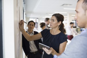 Businesswoman writing at wall