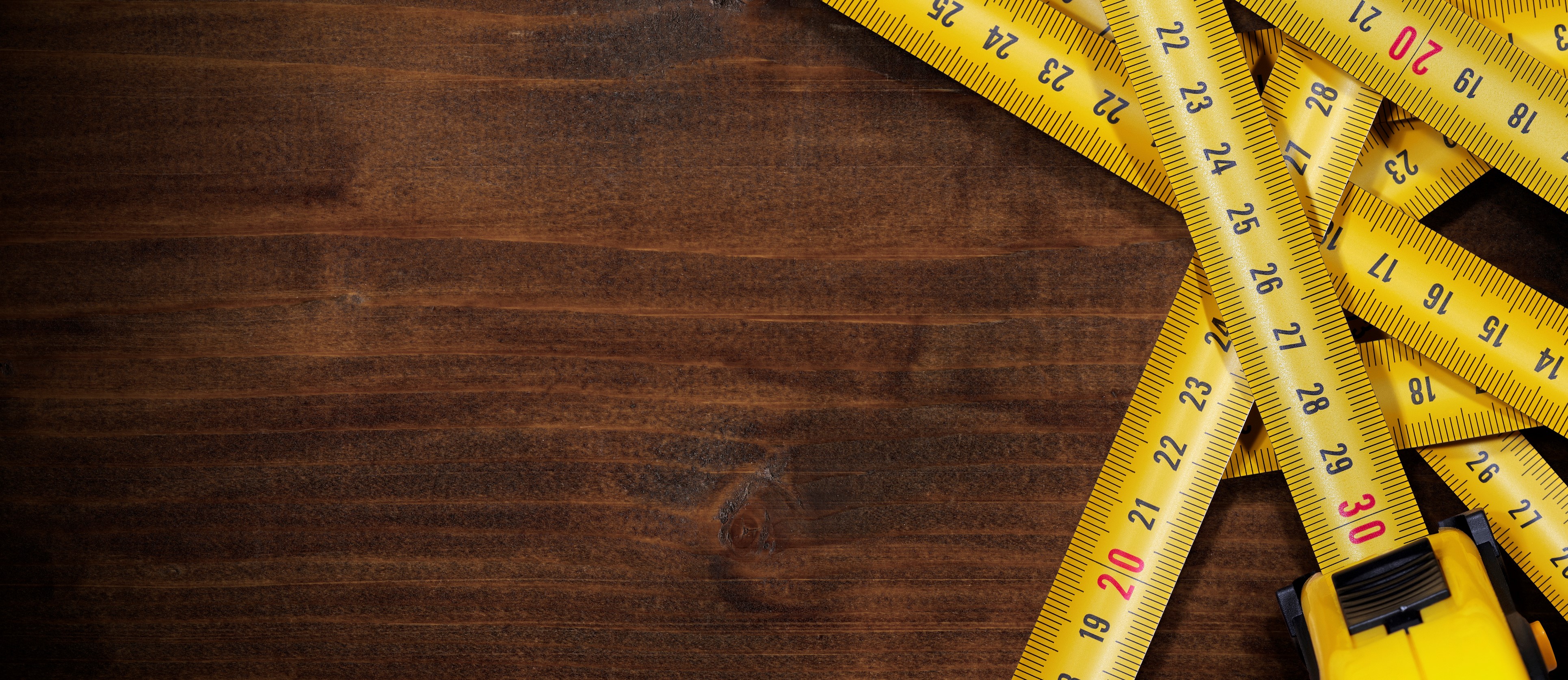 Tape Measures on Brown Wooden Background